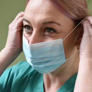 Healthcare assistant putting on mask
