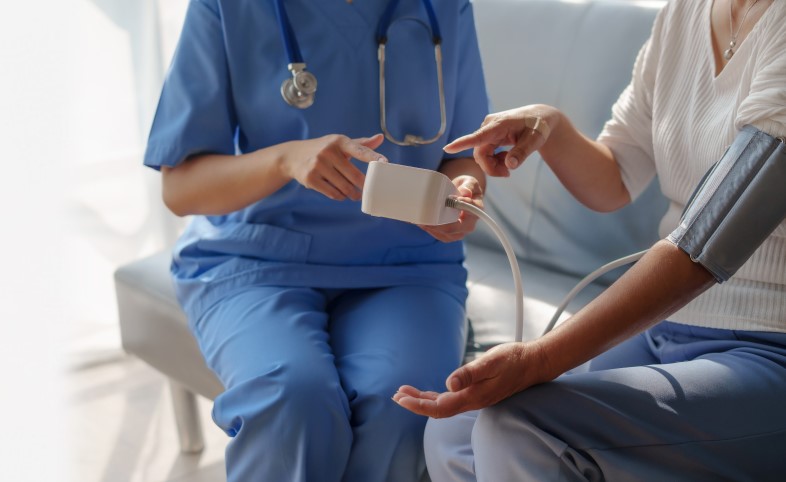 Clinician with a patient taking their blood pressure