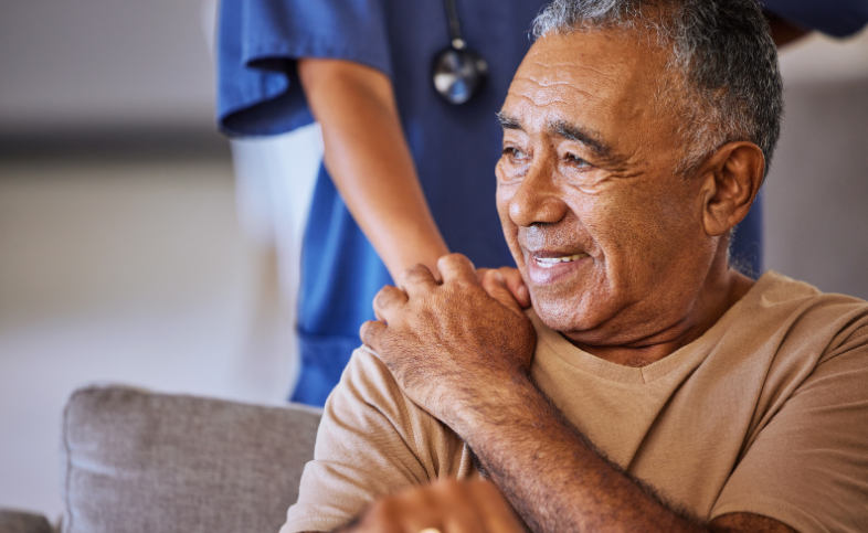 Patient holding person in scrub's hand on their shoulder