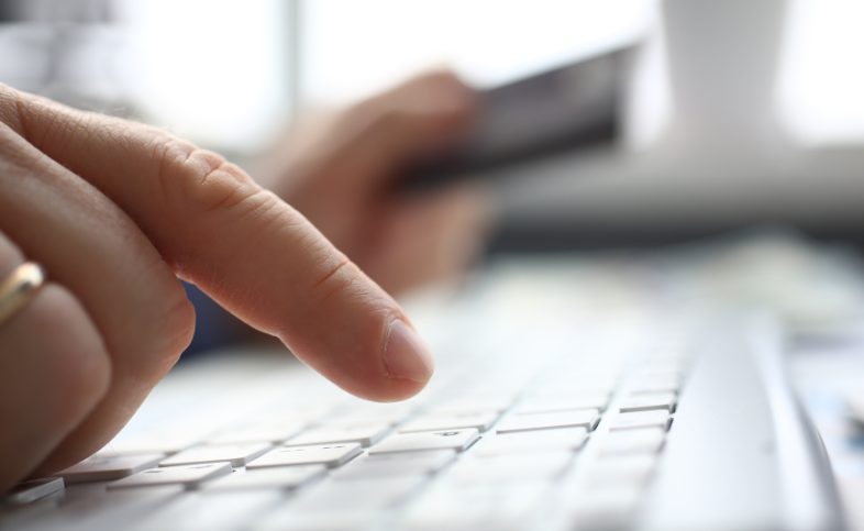 Close up image of a hand typing on a laptop