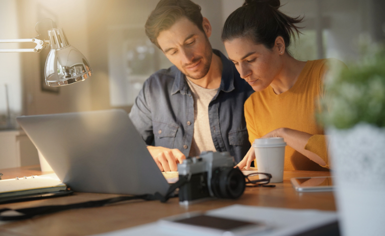 Two people work together on a laptop