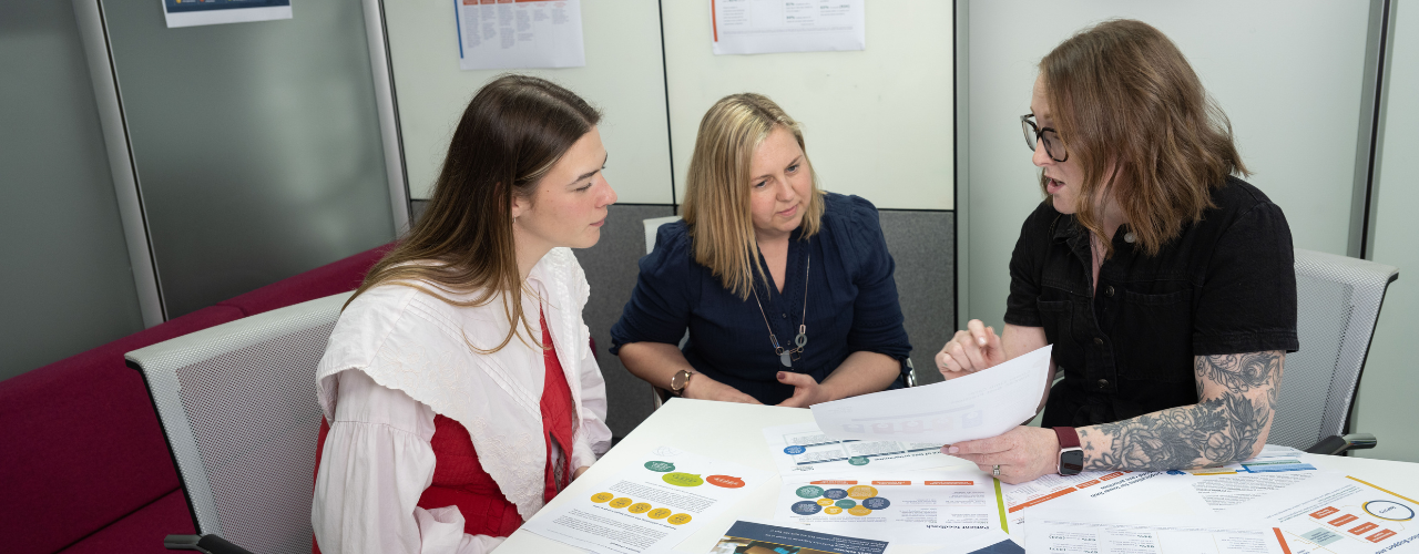 Maddie, Sarah and Amy look at documents together
