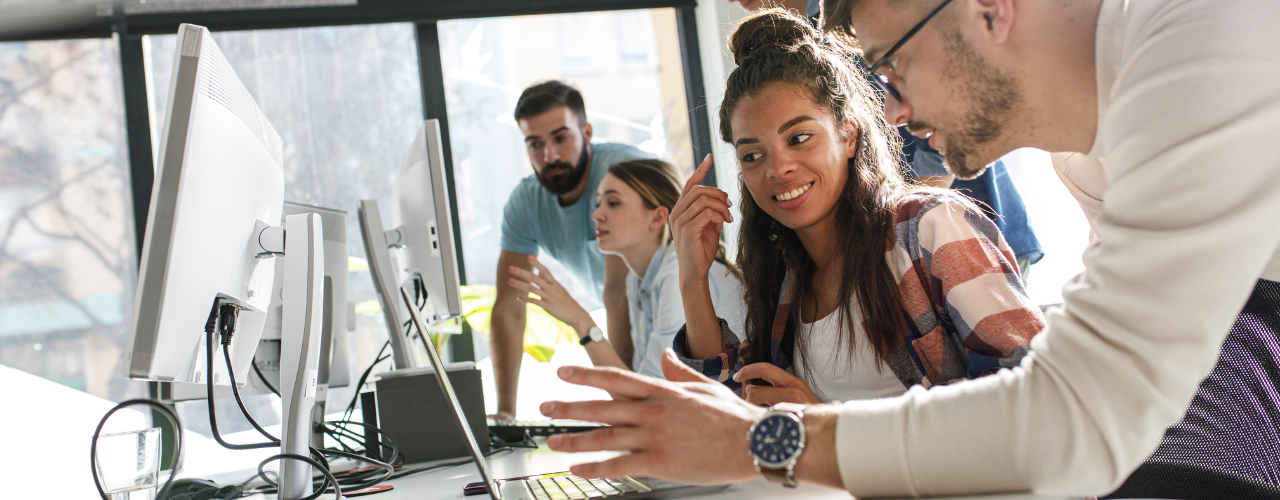 Group of adults work together in front of a computer