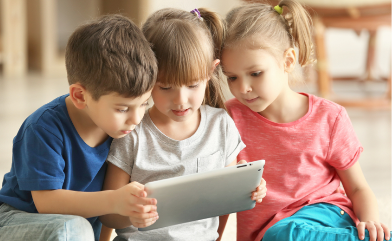 three small children using an ipad together