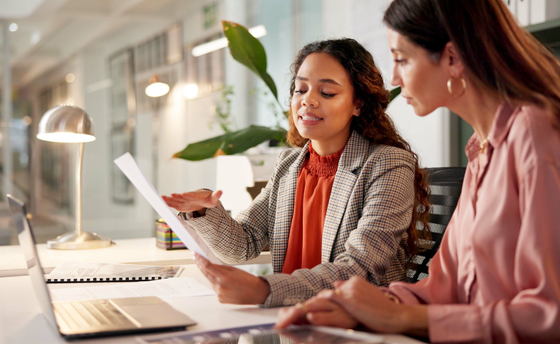Two women look at document together