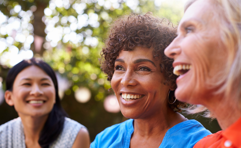 A group of three women - of different ages and races - outside together