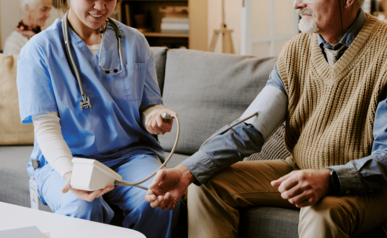 Man sat next to a nurse giving him blood pressure check
