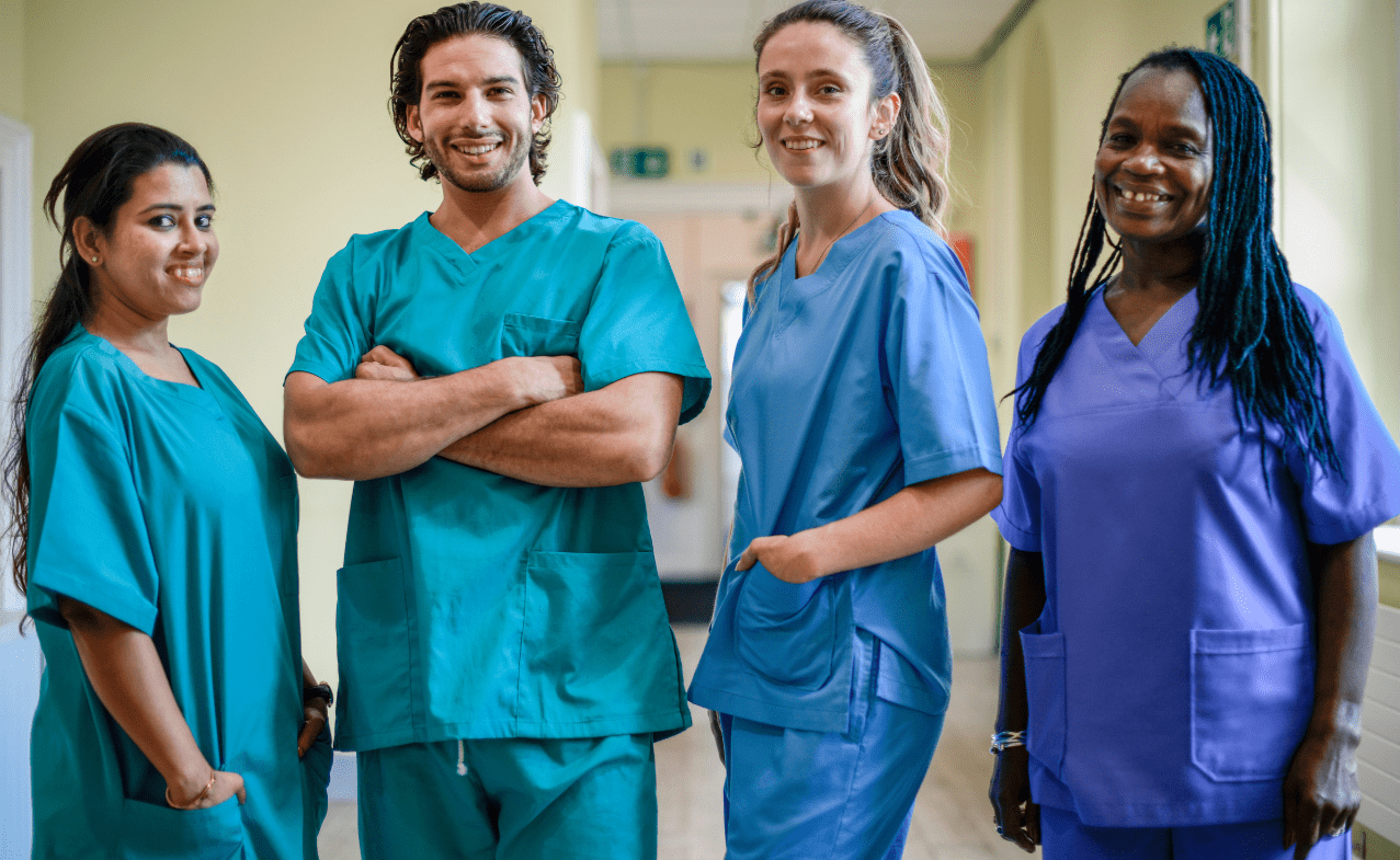 Group of four nurses in scrubs stand together