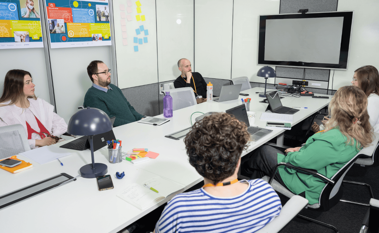 Group of Health Innovation East staff sit round a table together having a meeting